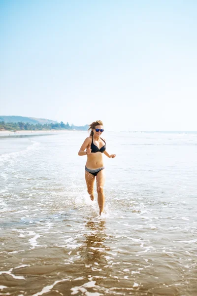 Donna su ampia spiaggia sabbiosa — Foto Stock