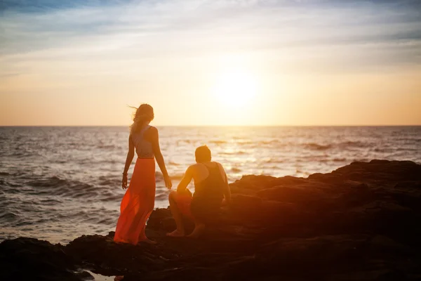 Couple sit on the rock and wait for sunset — Stock Photo, Image