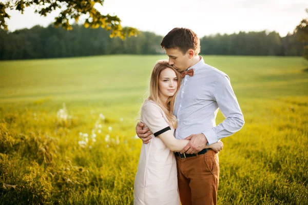 Sensual outdoor portrait of young stylish couple posing in field — Stock Photo, Image