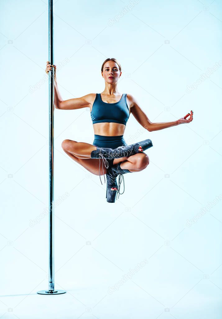 Young pole dance woman sitting in yoga pose super trick