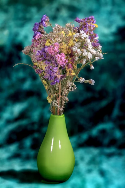 Букет разноцветных диких цветов в вазе на зеленом фоне — стоковое фото