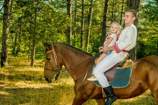 Jovem pai filha rola no cavalo na floresta — Fotografia de Stock