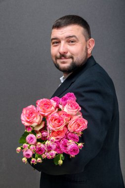 Üzerinde gül buketi olan ceketli bir gencin resmi.