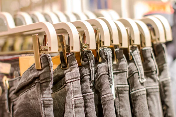 Anteprima jeans appesi a un appendiabiti nel negozio — Foto Stock