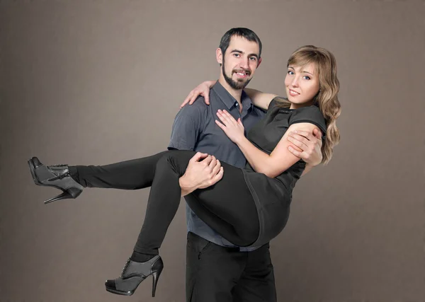 Young men holding woman in arms — Stock Photo, Image