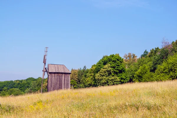 Ukrainian wooden windmill windmill stands near a forest in the f — Stock Photo, Image