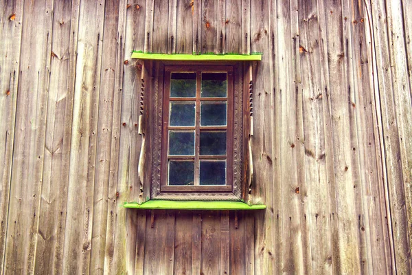 Carved frame and window in the old wooden house from boards — Stock Photo, Image