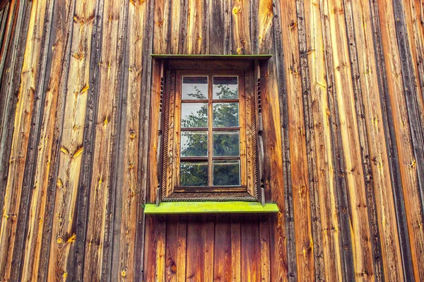 Carved frame and window in the old wooden house from boards — Stock Photo, Image