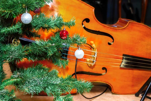 Bass lies under the tree Christmas decorations — Stock Photo, Image