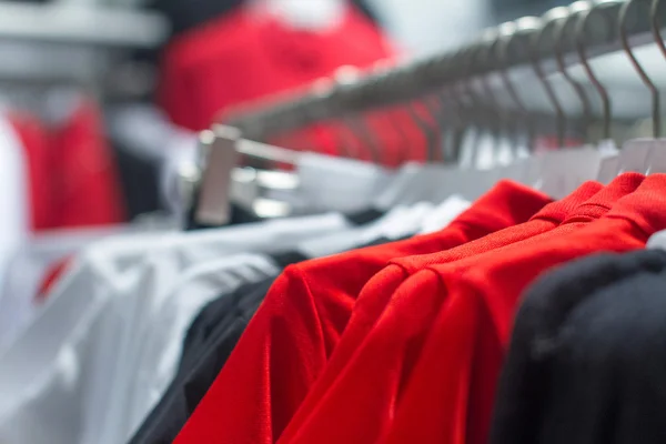 Red shirt hanging on a hanger in the store — Stock Photo, Image