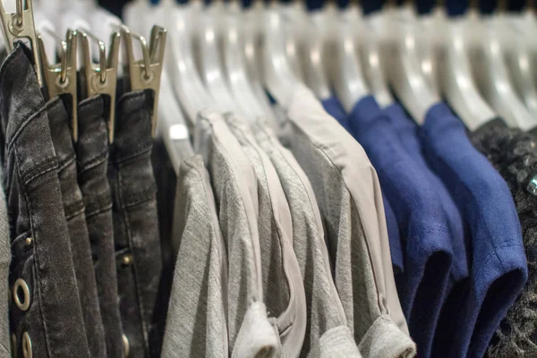 Jeans and T-shirts hanging on a hanger in the store — Stock Photo, Image