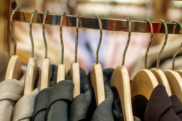 Chaquetas elegantes colgando en el estante en la tienda — Foto de Stock