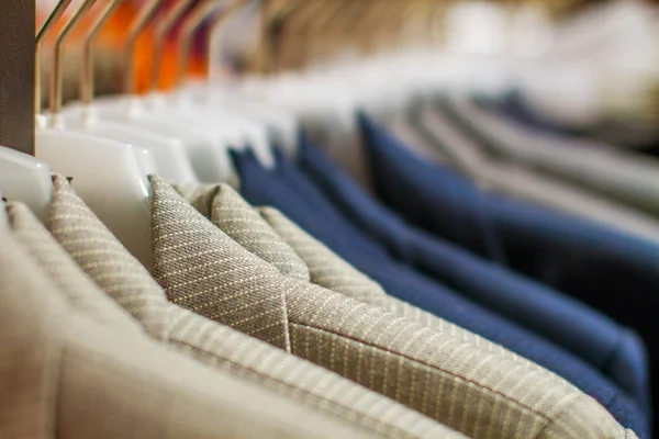 Stylish jackets hanging on the rack in the store — Stock Photo, Image