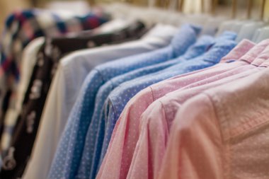 bir askı üzerinde asılı mavi ve pembe puantiyeli gömlek