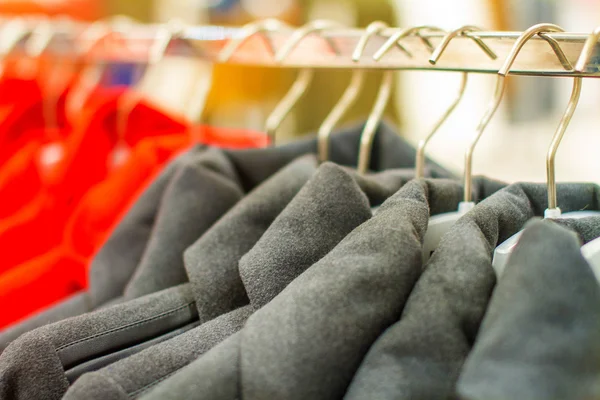 Abrigo negro femenino con botones cuelga en una percha en la tienda — Foto de Stock