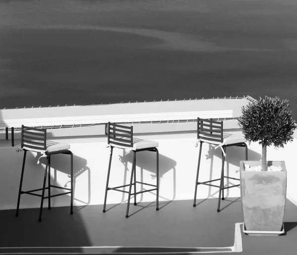 Greece. Santorini island. An open air cafe over the sea. In blac — Stock Photo, Image