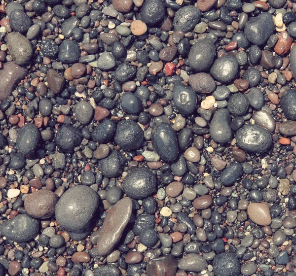 Gestemde ronde zee stenen op het strand van Santorini eiland als abstr — Stockfoto