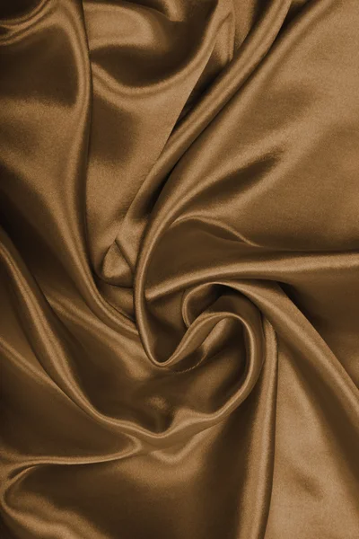 Гладкий элегантный коричневый шелк или атлас в качестве фона. В тонированном виде — стоковое фото
