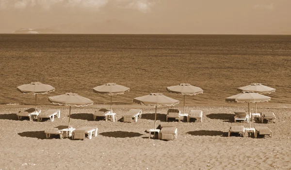 Griechenland. kos Insel. kefalos. Liegestühle und Sonnenschirme am Strand. — Stockfoto