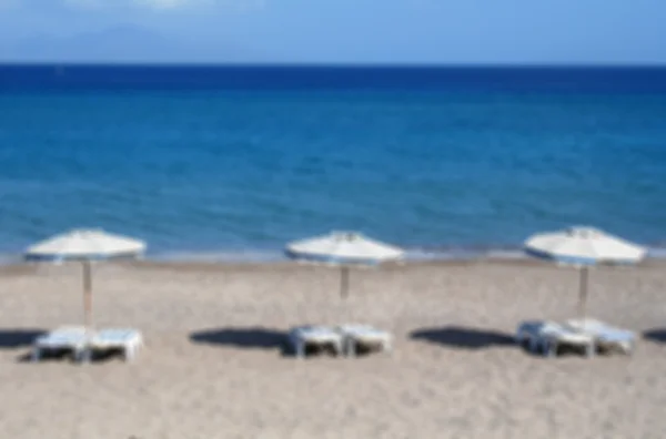 Liegestühle und Sonnenschirme am Strand von Kefalos — Stockfoto