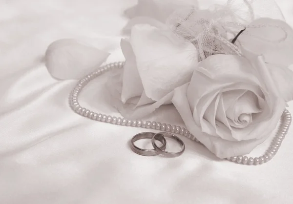 Snubní prsteny a růže jako svatební pozadí. V sépie tónovaný. R — Stock fotografie