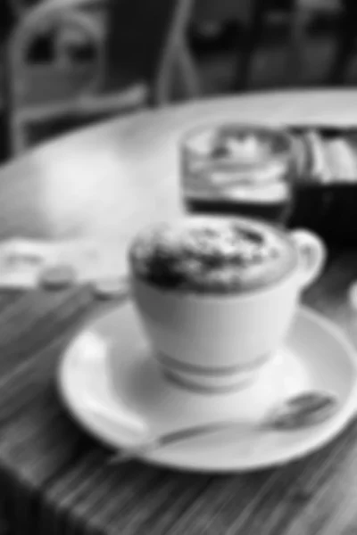 A cup of coffee in coffee shop. In blur style. In black and whit — Stock Photo, Image