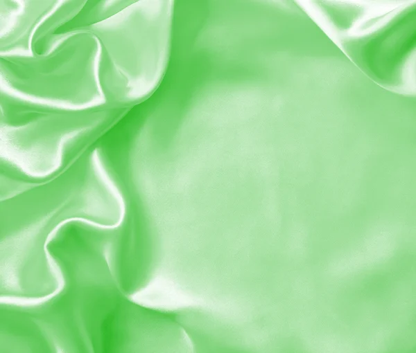 ผ้าไหมสีเขียวเรียบหรือเนื้อผ้าซาตินเป็นพื้นหลัง — ภาพถ่ายสต็อก
