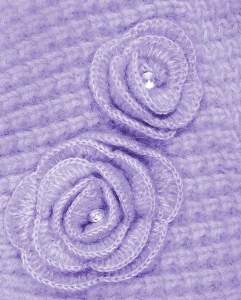 Lilac wool flowers on lilac wool knitted as background — Stock Photo, Image