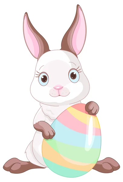 Easter bunny with colored egg — Stock Vector