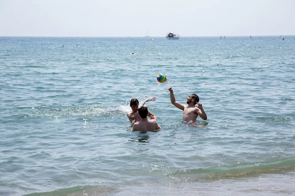 Мальчики играют с мячом в воде на пляже Barcelonetta — стоковое фото