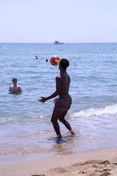 Meninos brincando com uma bola na água na praia de Barceloneta — Fotografia de Stock