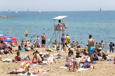 Güvenlik görevlisi Barceloneta plaja turistlere izlerken