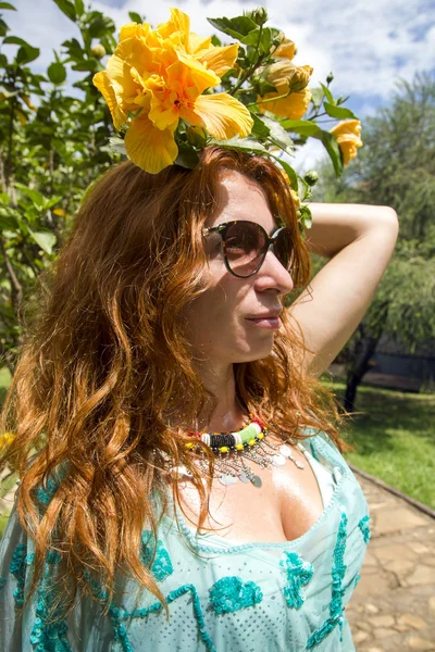 Beautiful brunette in a bathing suit at a tropical garden — Stock Photo, Image