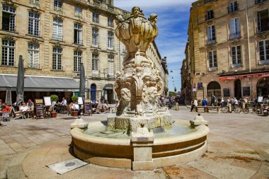 FRANCE, BORDEAUX, MAYIS, 19, 2019 - Parlamento Meydanı veya Parlement Meydanı, Bordeaux. Tarihi meydandaki kalabalıkta süslü bir çeşme var.