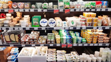 Letonya, Riga, 13 Şubat, 2021 - Riga, Letonya 'daki alışveriş merkezinde dünyanın dört bir yanından çeşitli peynirlerle dolu raflar