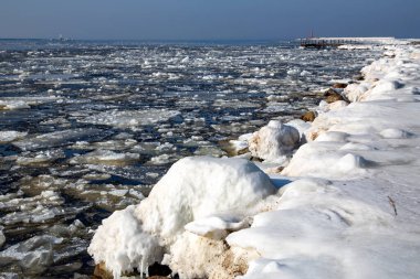 Baltık Denizi 'ndeki Mangalsala rıhtımındaki deniz fenerine giden buzlu yol Riga limanı, Letonya, Avrupa
