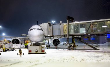 LATVIA, RIGA, MARCH, 2021 - Kış sabahının erken saatlerinde uçmak ve uçağa Riga Uluslararası Havaalanı 'nda bagaj yüklemek için uçak hazırlığı. Letonya