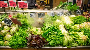 İspanya, BARCELONA, MARCH, 2021 - Biyoloji mağazası Barselona 'da tazeliği mümkün olduğunca korumak için nemli sis ve sebzelerle sulanan çeşitli taze yeşillikler. Bahar sağlıklı vejetaryen yemekleri pişirme malzemeleri. 