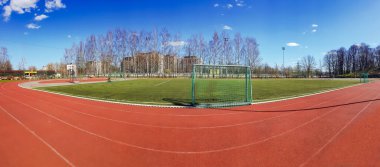 LATVIA, RIGA, APRIL, 2021 - Riga, Letonya 'da kale ve suni sahası olan koşu pistleri ve futbol sahası olan stadyum. Koşu pisti, atletizm için yapay bir koşu alanıdır..