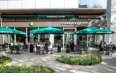 İspanya, BARCELONA, Mart 2021: İnsanlar kahve içer ve Barcelona 'daki Starbucks Kafe' nin açık verandasında canlı iletişim kurar. İspanya