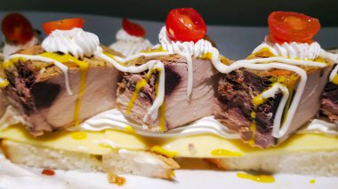 Kremalı sosla süslenmiş peynirli tuna bifteği.