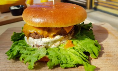 Taze ızgara hamburger ve taze salata yaprakları ve hardal sosu yenmeye hazır. Afiyet olsun. Fast food.