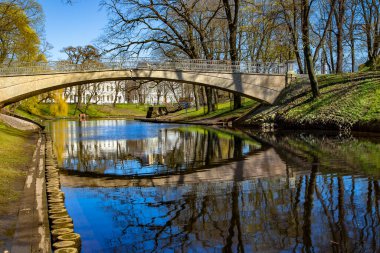 Riga şehir parkındaki Riga nehir kanalı üzerindeki taş köprü, Letonya 'nın başkenti.
