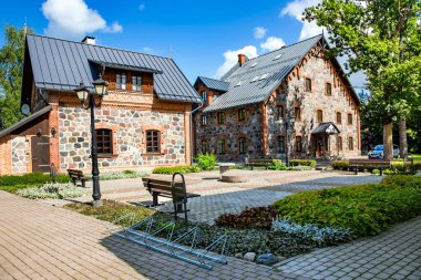 LATVIA, CESIS, AUGust, 2020 - Eski taştan yeniden inşa edilmiş binaları olan modern mimari - Cesis, Letonya 'da iyi korunmuş bahçesi olan kayalar