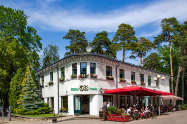 LATVIA, JURMALA, JULY, 2021 - Jurmala, Letonya 'da Jomas caddesinde açık verandalı bir kafe. Jurmala, Baltık Denizi 'nin Riga Körfezi kıyısında 32 km uzunluğunda bir sahil kentidir.