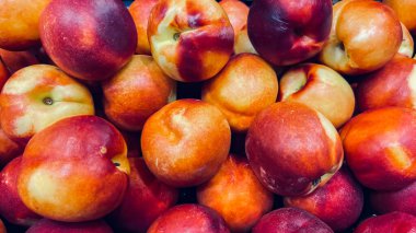 Büyük, olgun ve sulu kırmızı nektarinler. Satılık büyük bir nektarin grubu. Hasat et. Tatlı tatlı.