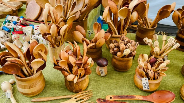Handmade wooden souvenirs for tourists. Beautiful kitchen utensils: spoons, forks and cutting boards in Riga street market, Latvia. Traditional craft.