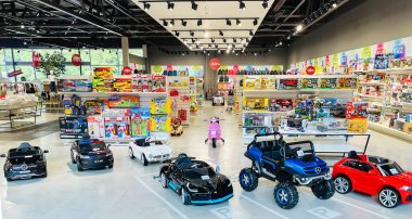 LATVIA, RIGA, AUGUST, 2021 - Modern children`s toys store with electric toy cars in the foreground in SKY&MORE shopping mall in Riga, Latvia clipart