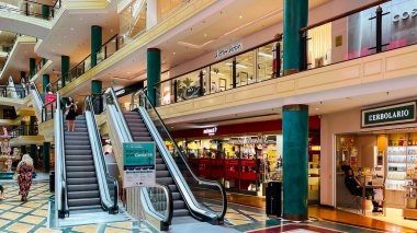 LATVIA, RIGA, AUGust, 2021 - Riga, Letonya 'da moda dükkanları ve modern mimarisi olan Galleria Riga alışveriş merkezindeki yürüyen merdivenler