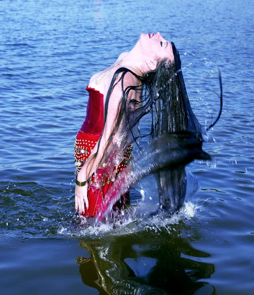 Jovem mulher fazendo um cabelo de respingo de água no mar — Fotografia de Stock